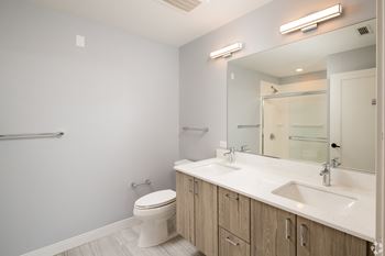 a bathroom with a large mirror and a toilet and sink